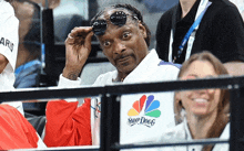 snoop dogg is wearing sunglasses while watching a game