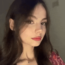 a close up of a woman 's face with long dark hair and red lips .