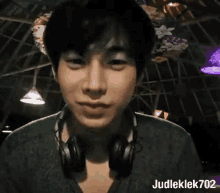 a young man wearing headphones is looking at the camera while smiling .