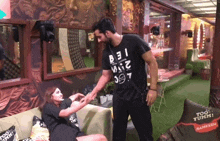 a man in a t-shirt that says ' bei ' on it holds a woman 's hand