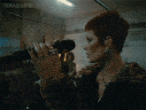 a woman singing into a microphone with the words terasgifs written above her