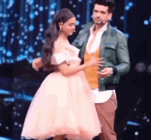 a man and a woman are dancing on a stage together .