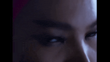 a close up of a woman 's eyes in the dark in a dark room .