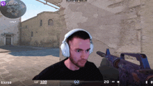 a man wearing headphones is playing a video game with a twitch logo in the background