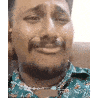 a man with a beard is crying and wearing a green shirt .