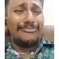a man with a beard is crying and wearing a green shirt .