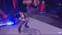a wrestler is standing on a stage holding a trophy .