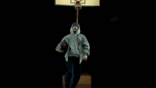 a group of children are dancing in front of a basketball hoop in a dark room