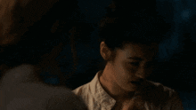 a woman is smiling and saying to be a freak in a dark room .