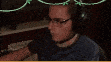a man wearing glasses and headphones is sitting in front of a computer screen