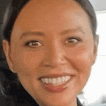 a close up of a woman 's face with a big smile on her face .