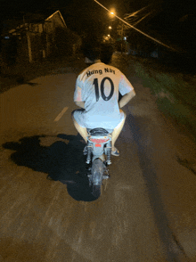 a person on a motorcycle wearing a shirt that says hung nay