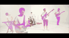a man is playing a guitar in front of a keyboard and a drum set