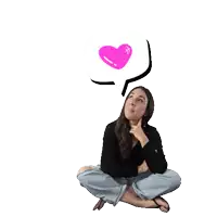 a woman is sitting on the floor with a heart in a pink thought bubble above her head