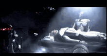 a robot is laying on a trailer in a dark room with smoke coming out of it