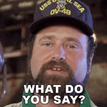 a man with a beard wearing a uss seal sea hat