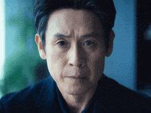 a close up of a man 's face with a blue background
