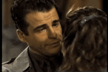 a man and a woman are hugging each other and kissing .
