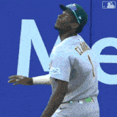 a baseball player reaches up to catch a ball in front of a sign that says men
