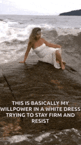 a woman in a white dress is sitting on a rock in the water .