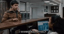 a man is talking to a woman at a counter in a laundromat and saying `` i wanna kill myself ''