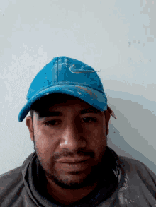a man wearing a blue nike hat looks down at the camera