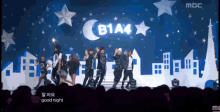 a group of people are performing on a stage with a b1a4 sign above them