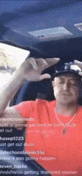 a man in a red shirt is taking a picture of himself with a cell phone