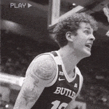 a black and white photo of a man in a butler jersey