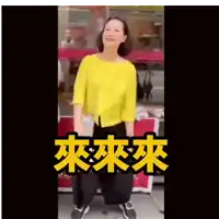 a woman in a yellow shirt and black pants is dancing in front of a sign that says ' chinese ' on it .