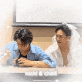 two men sitting at a table with nishi & chofi written on the bottom right