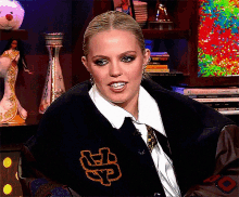 a woman wearing a black jacket with the letter np embroidered on it