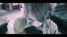 a person with headphones on looks at their face in a mirror