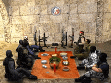 a group of soldiers sit around a table with bowls of food and a clock above them