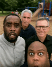 a group of men are posing for a picture and one of them is making a surprised face