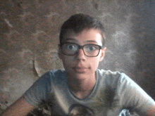 a young man wearing glasses and a blue shirt
