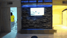 a stone wall with a tv on it and the words intuition ambition union seguridad written above it
