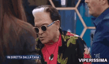 a man wearing sunglasses and a red shirt is on a tv show called viperissima .