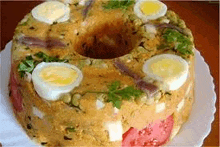 a cake with eggs , tomatoes , and onions on a plate on a table .