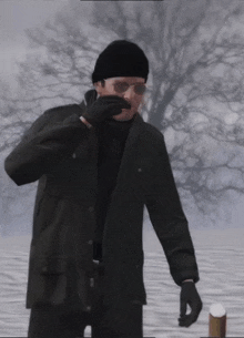 a man wearing a black jacket and black gloves stands in a snowy field