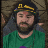 a man with a beard wearing headphones and a hat that says d lemon