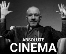 a black and white photo of a man with his hands in the air with the words absolute cinema below him
