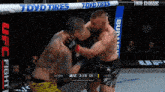 two men are fighting in a ufc ring with a banner for toyo tires in the background