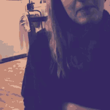 a woman in a black shirt stands in a kitchen