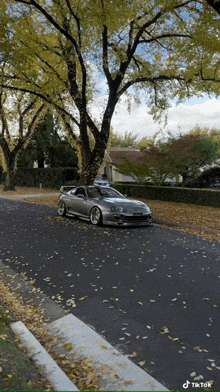a car is parked on the side of the road with leaves on it