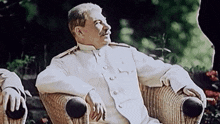 a man in a white uniform is sitting in a chair