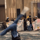 a person is doing a handstand in front of a group of people holding signs one of which says ' a '