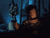a woman smoking a cigarette in front of a statue of a deity