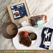 a table with a plate of food and a box of steak sauce