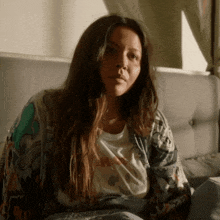 a woman is sitting on a bed wearing a t-shirt that says ' i love you ' on it